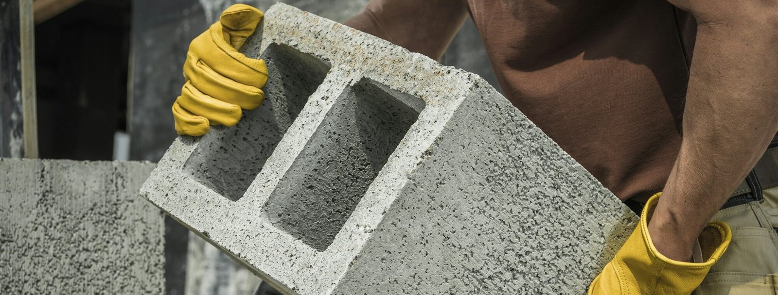Construction Worker Moving Hollow Dense Concrete Blocks